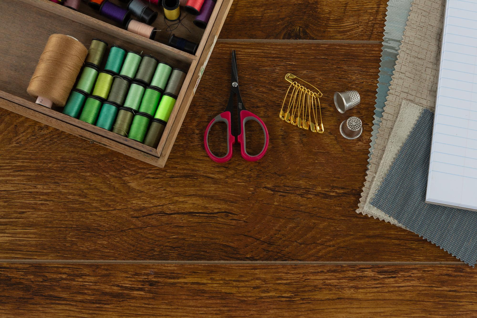 atelier table with threads, needles and embroidered swatches